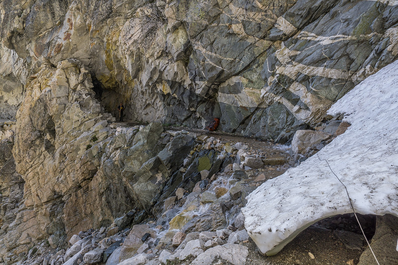 Backpacks and rope staged beside the snow chute for the exposed crossing
