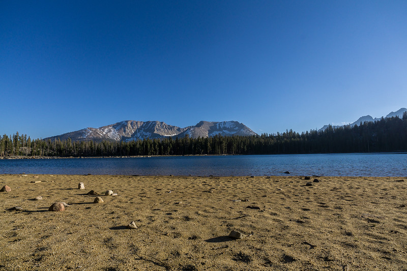 Sandy shore of Moraine Lake beneath the Sierra Nevada peaks