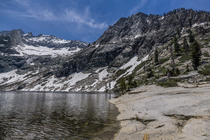Snow-covered granite cliffs rising from the shore of Hamilton Lake