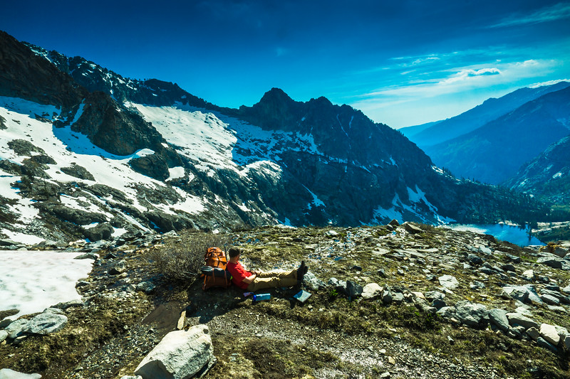 Backpacker resting on a rocky ledge above Hamilton Lake
