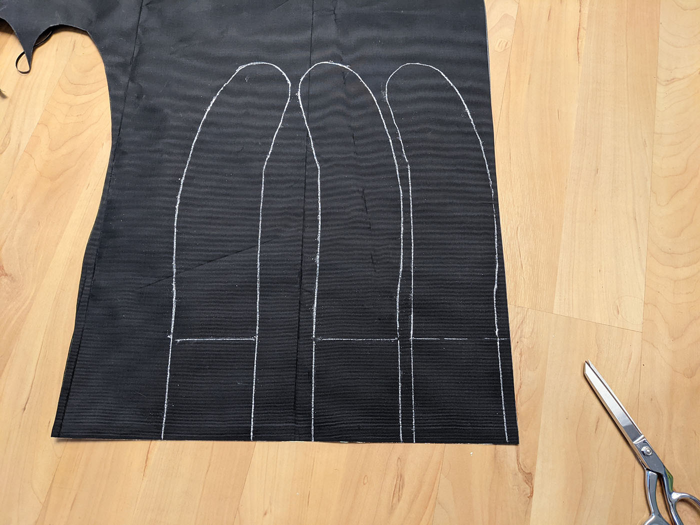 myog-shoulder-straps.jpg Three shoulder strap patterns traced in chalk on black fabric