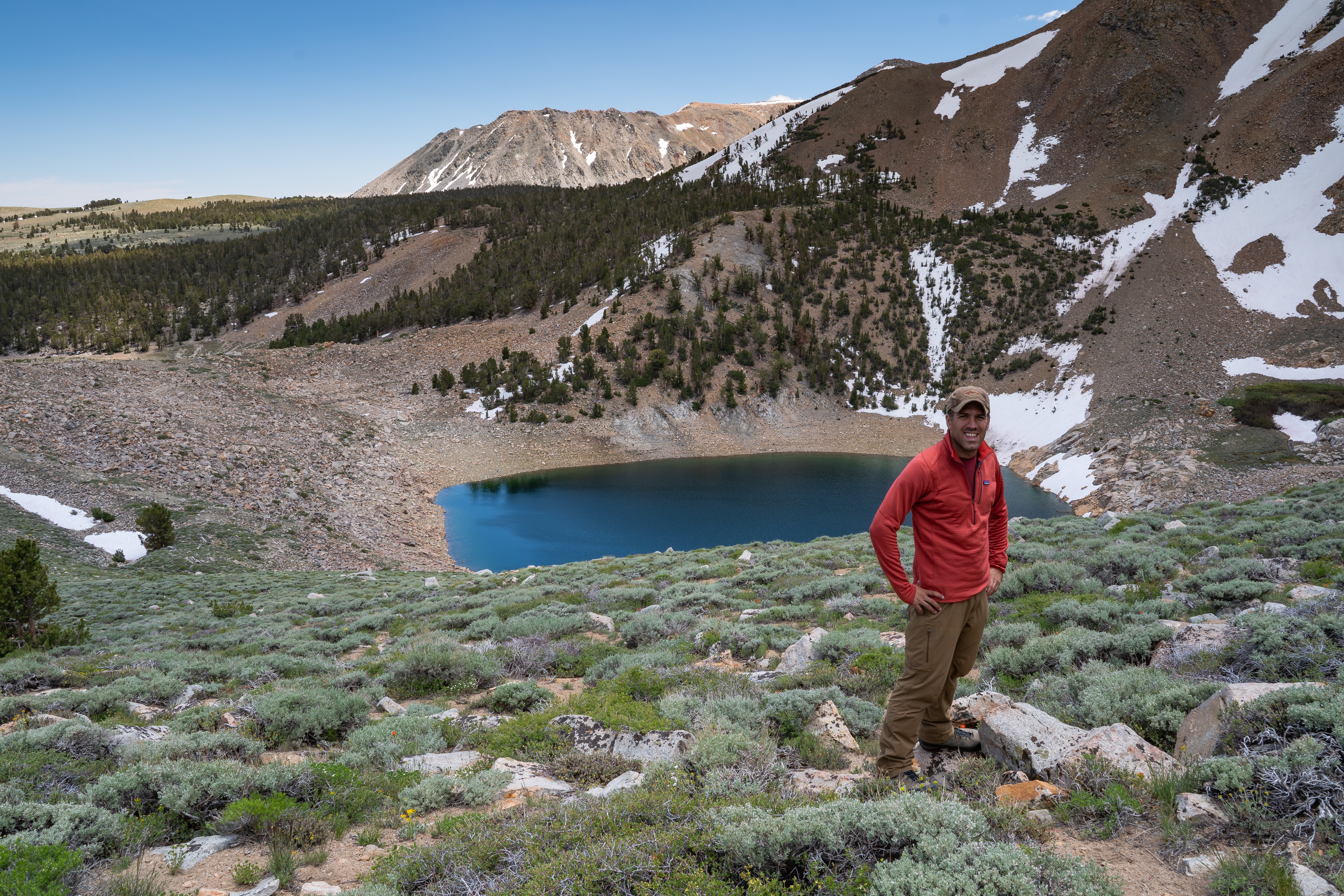 mcj07861.jpeg Hiker standing above a deep blue alpine lake in Coyote Flats