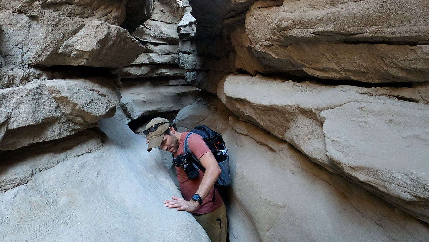 narrow-slot-canyon-2.jpg Hiker squeezing sideways through one of The Slot's tightest gaps