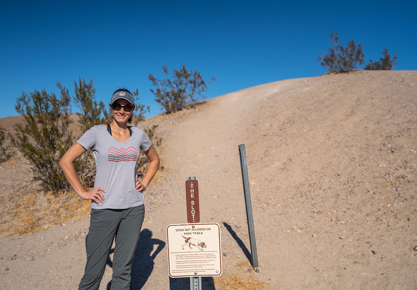 slot-canyon-trailhead.jpg Hiker beside The Slot trailhead marker and no-dogs sign