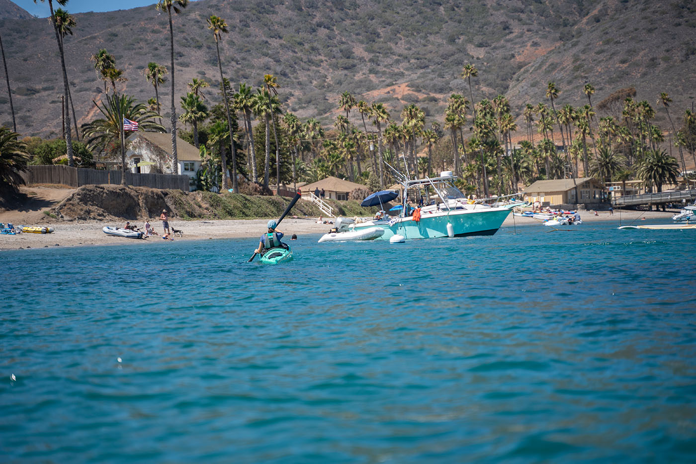 two-harbors-catalina-island.jpg Teal kayak entering Two Harbors past anchored boats and palm trees