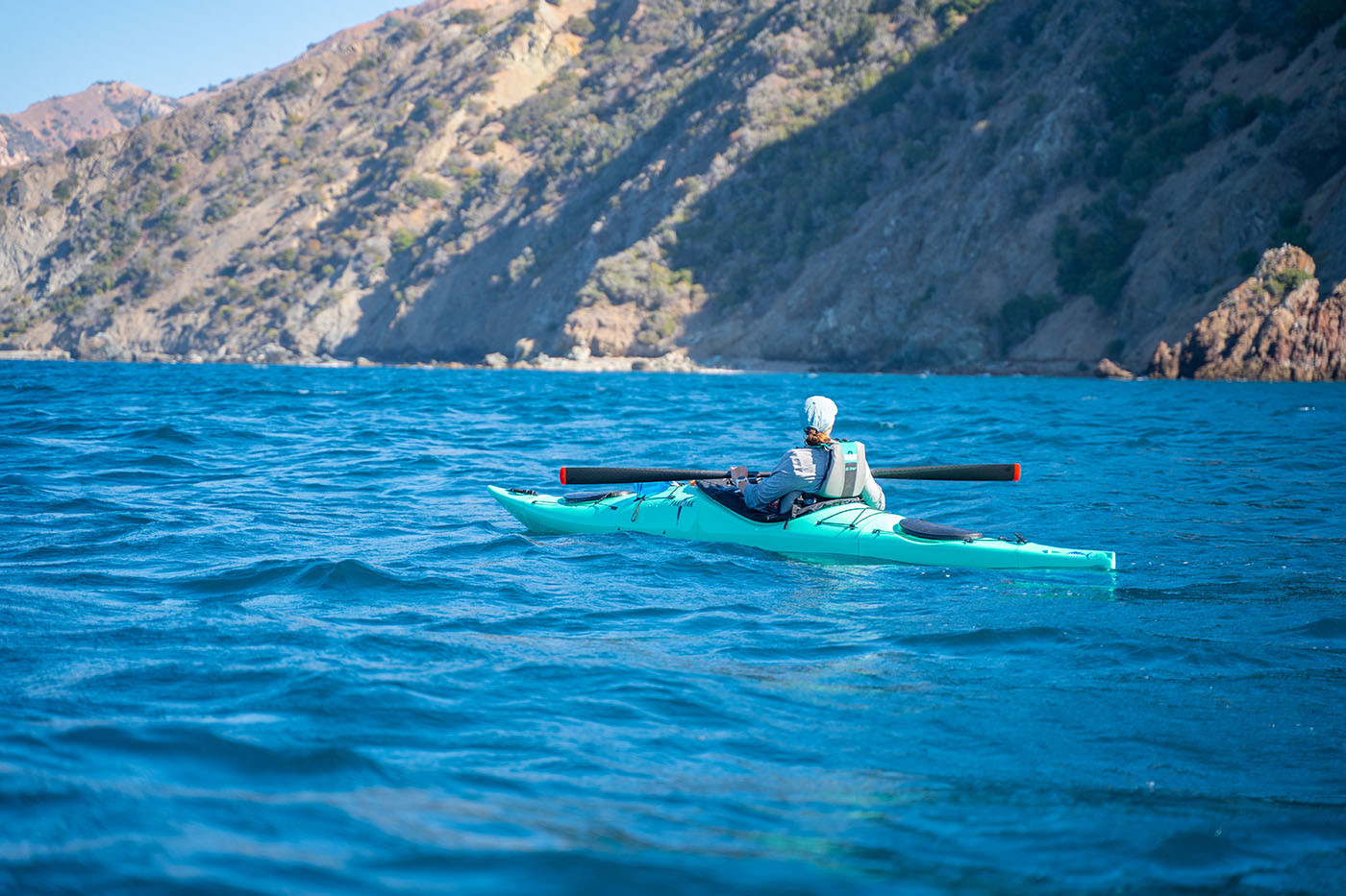 pakayak-catalina-island.jpg Kayaker resting in a teal Pakayak against the rugged Catalina coast