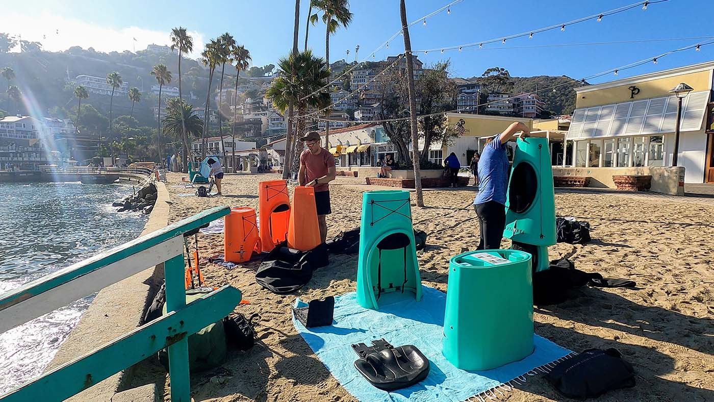 building-pakayaks-in-catalina.jpg Two kayakers assembling orange and teal Pakayaks on an Avalon beach